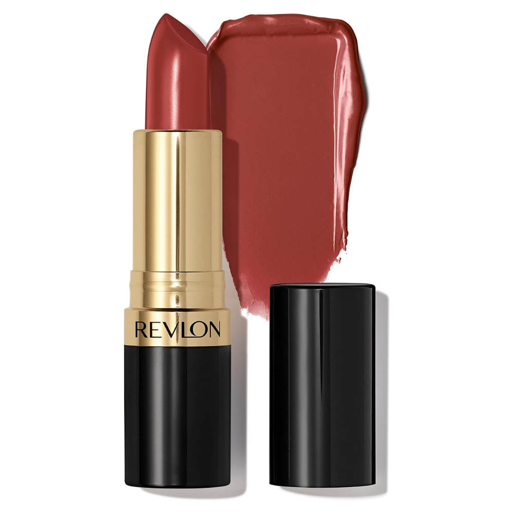 A Revlon lipstick in a warm brick red shade, shown with its gold and black tube, a detached black cap, and a large product smear behind it on a white background.
