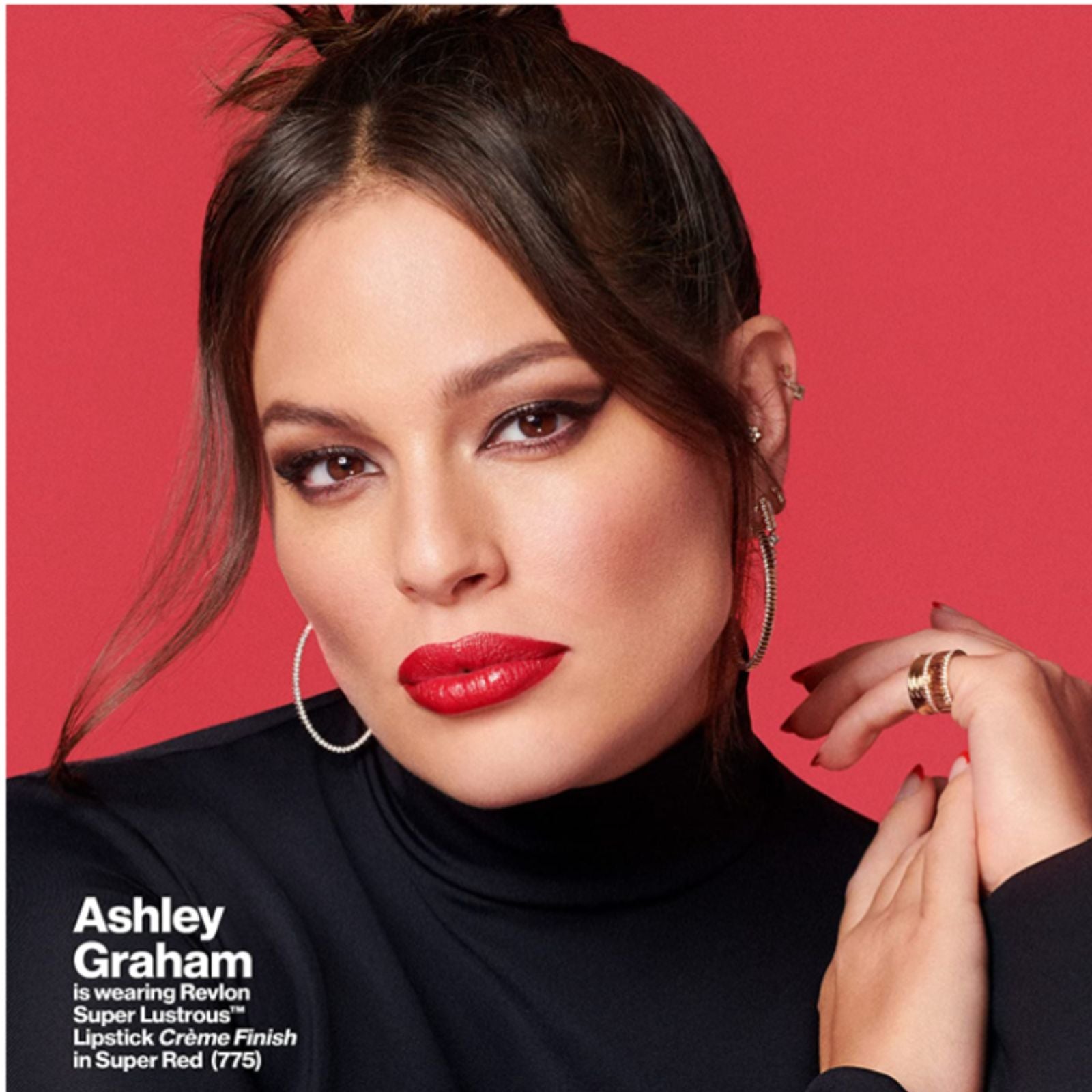 A close-up portrait of model Ashley Graham wearing a bright red lipstick against a solid red background, with text on the lower left identifying the lipstick as Revlon Super Lustrous Lipstick Creme Finish in Super Red (775).